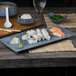 A rectangular blue Biseki stoneware platter with sushi on a table.