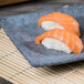 A rectangular blue 10 Strawberry Street stoneware platter with sushi on it.
