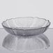 A clear glass Arcoroc Fleur Compote bowl on a table with a leaf design.