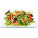 A salad with tomatoes, lettuce and cheese on a square Libbey glass plate.
