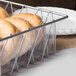 A Clipper Mill clear plastic liner in a basket of bagels on a hotel buffet table.