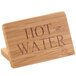 A Cal-Mil bamboo wood sign that says "Hot Water" on a counter.