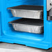 A blue Cambro food pan carrier with foil trays inside.