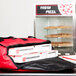 A red San Jamar insulated pizza delivery bag with pizza boxes inside.