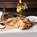 A Clipper Mill clear acrylic basket divider holding pastries on a table.