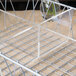A Clipper Mill metal wire basket with clear plastic dividers inside.