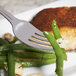 A 10 Strawberry Street Pearl stainless steel dinner fork with green beans on it on a plate.