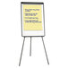 A Universal tripod style white board on a metal stand with a yellow notepad on it.