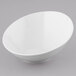 A Tuxton porcelain white serving bowl with a slanted design on a gray background.