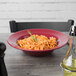 A Tuxton tall china pasta bowl filled with spaghetti on a table.