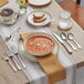 A table set with Acopa Edgeworth stainless steel salad / dessert forks, spoons, and knives.