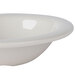 A close-up of a white Carlisle Sierrus melamine bowl with a rim.
