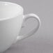 A close-up of a Libbey Basics bright white porcelain low cup with a handle.