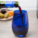 A Stolzle China Blue stemless wine glass filled with wine on a table.
