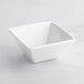 An Acopa bright white square bowl on a white surface.