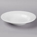 A Libbey bright white porcelain soup bowl with a wavy design on the rim.
