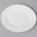 A white Libbey oval porcelain platter with a white rim on a gray surface.