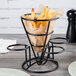 A black metal Clipper Mill iron cone basket with french fries in it.