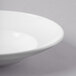 A close-up of a Libbey bright white porcelain bowl with a rim.