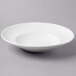 A Libbey Basics bright white porcelain entree/pasta bowl on a gray surface.