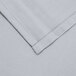 A close up of a gray hemmed cloth with folded edges.