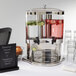 An American Metalcraft dual beverage server with glasses of water and a drink dispenser.