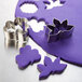 A purple plastic mold with metal leaf and flower cookie cutters.