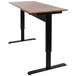 A Luxor 48" pneumatic adjustable height stand up desk with a black base and wood top.