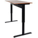 A Luxor black stand up desk with a black base and brown top.