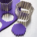 A close-up of Ateco stainless steel fluted hexagon cookie cutters.