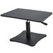 A black Victor adjustable height wood laptop stand on a black table with a metal base.