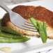 A Bon Chef stainless steel dinner fork on a plate with salmon and green beans.