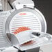 A meat slicer with a stainless steel slicer blade inside.