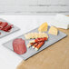 A Tablecraft natural cast aluminum rectangular cooling platter with meat and cheese on it.