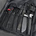 A Dexter-Russell black cutlery case with knives and other tools inside.
