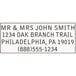 A close-up of a Trodat customizable message stamp with the words "Mr and Mrs John Smith, Oakland Branch Trail" and a number.