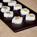 A Tablecraft Midnight Speckle cast aluminum long rectangular platter with sushi rolls.