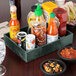 A HS Inc. jalapeno condiment organizer on a table with bowls of salsa and condiments.