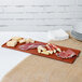 A Tablecraft copper cast aluminum rectangular cooling platter on a table with meat and cheese.