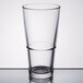 A close-up of a Libbey clear mixing glass with a rim.