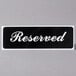 A black table tent sign that says "Reserved" in white text.