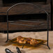 A Clipper Mill black iron powder coated 2 tier table riser with food on a table.