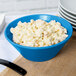 A Tablecraft sky blue cast aluminum serving bowl filled with macaroni salad.