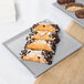 A Tablecraft natural cast aluminum rectangular cooling platter with pastries on it.