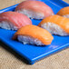 Sushi on a blue Tablecraft rectangular cooling platter.