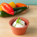A white bowl of cream cheese with green onions in an HS Inc. paprika ramekin.