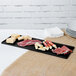 A Tablecraft black cast aluminum rectangular cooling platter with meat and cheese on it.