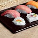A Tablecraft midnight speckle rectangular cast aluminum tray with sushi.