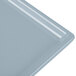 A close-up of a gray rectangular metal platter with a white surface.