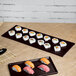 A Tablecraft Midnight Speckle cast aluminum rectangular cooling platter with sushi on a table.